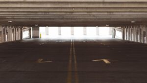 Real covered parking garage with concrete floor and traffic markings