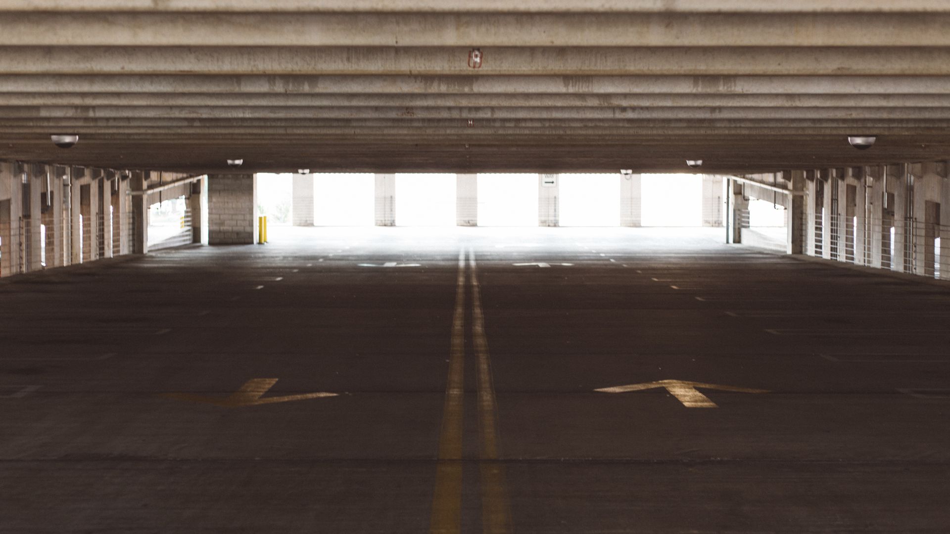 Real covered parking garage with concrete floor and traffic markings