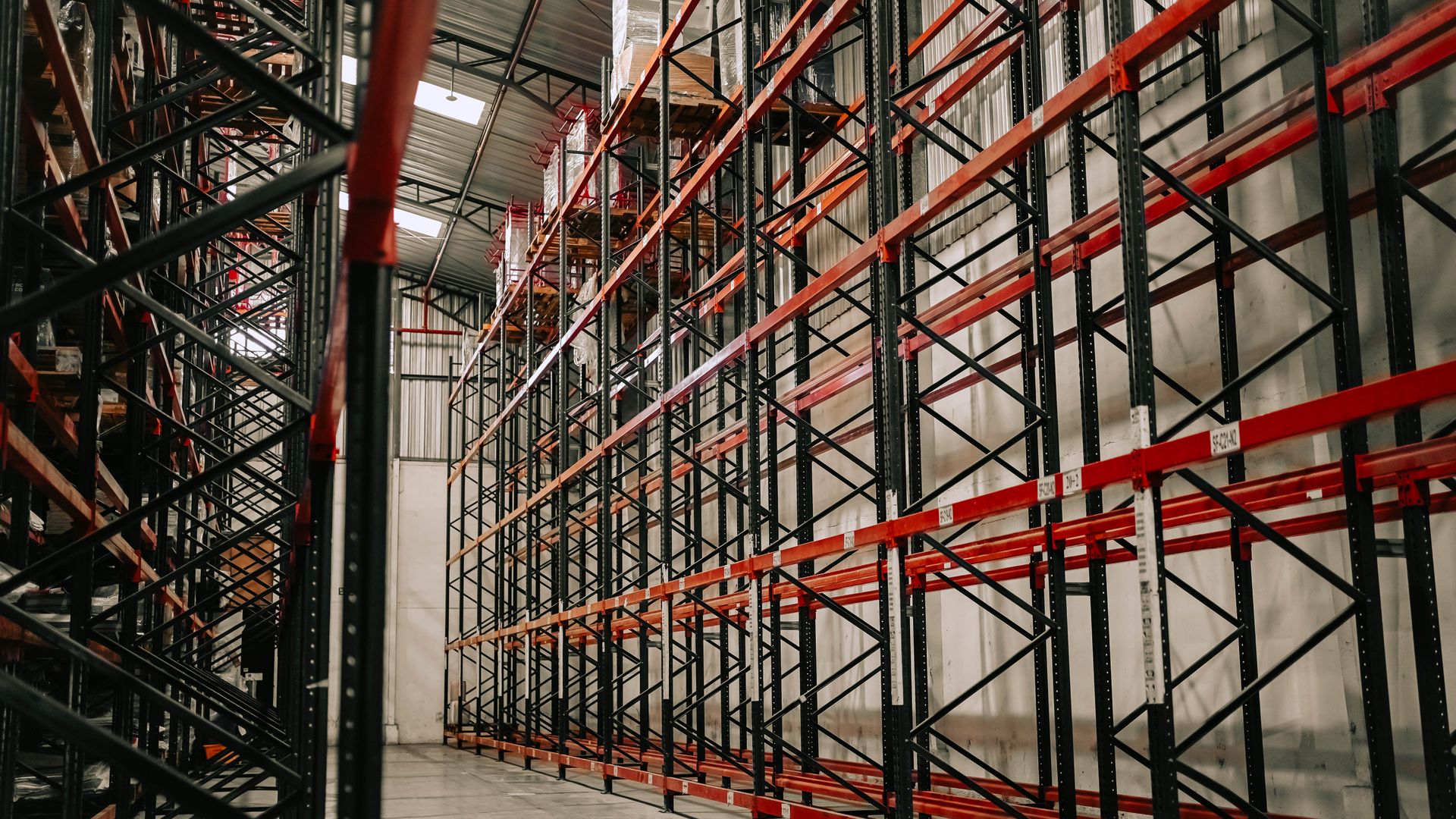 Real warehouse aisle with pallet racks and concrete floor